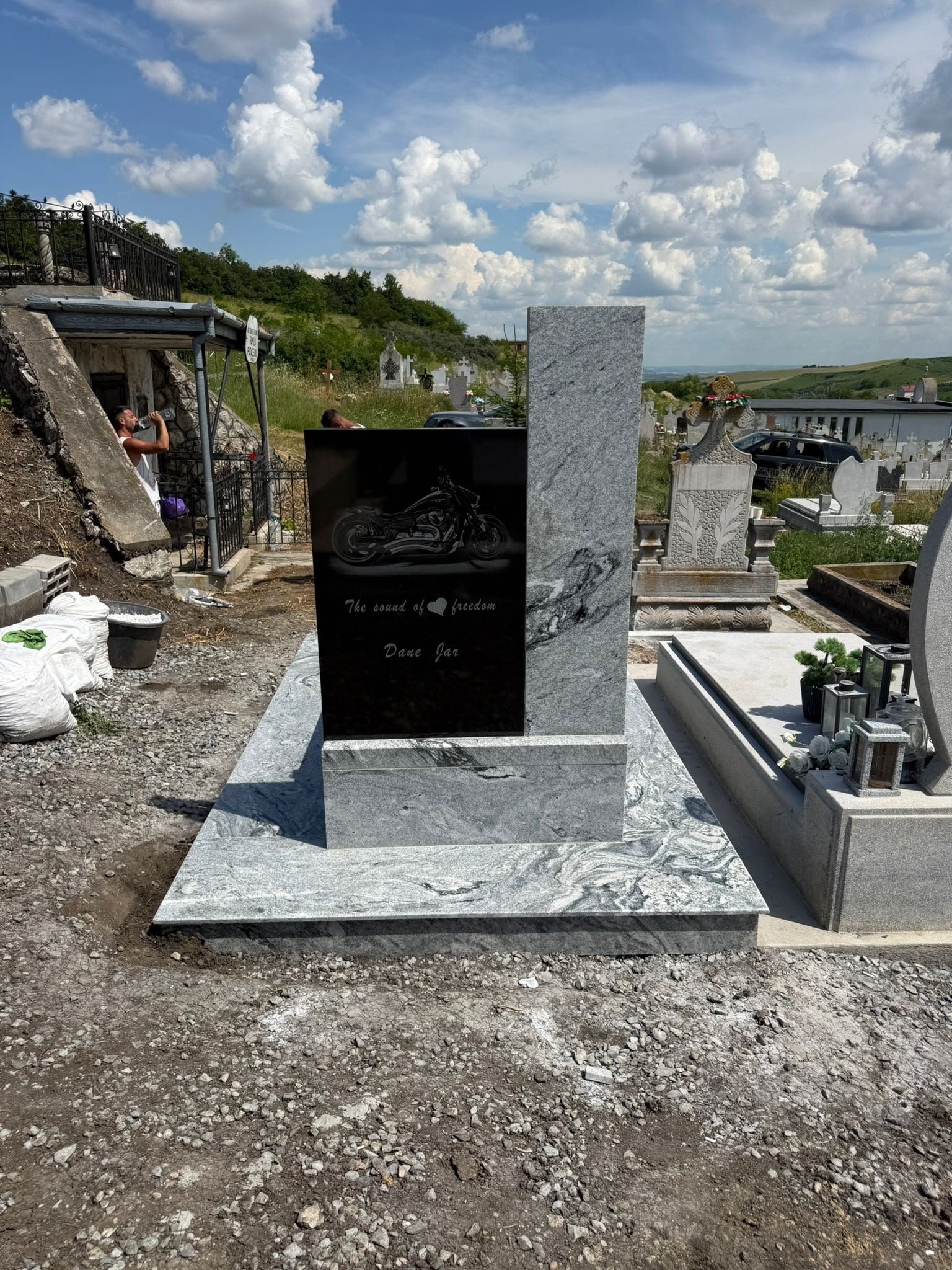 Monument funerar din granit gri cu placă neagră și contur modern