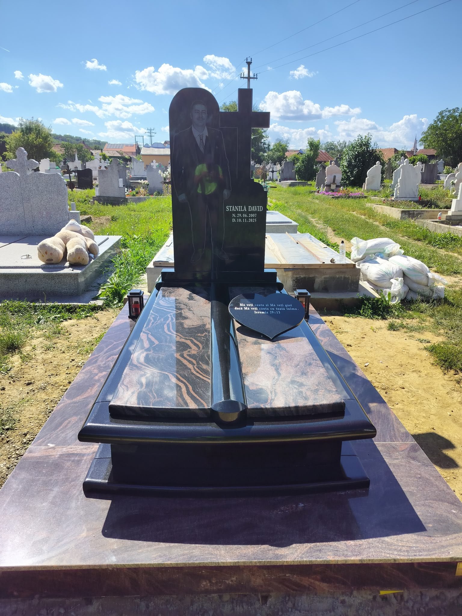 Monument funerar din granit închis cu cruce și placă în formă de inimă